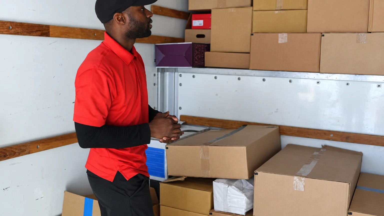 A mover organizing packed boxes inside a moving truck